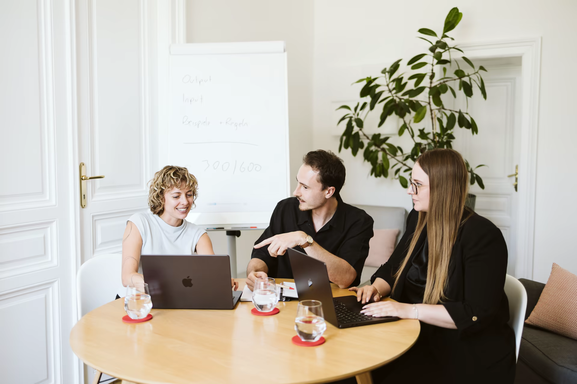 Drei Teammitglieder von Bacon & Bold bei der Zusammenarbeit im Wiener Büro